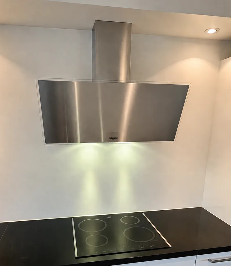 Nieuwe afzuigkap gemonteerd boven een kookplaat