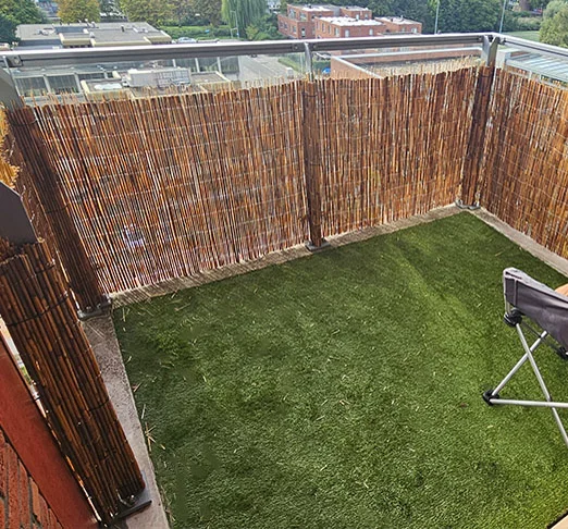 Balkon met nieuw kunstgras en een hoog dubbel privacyscherm