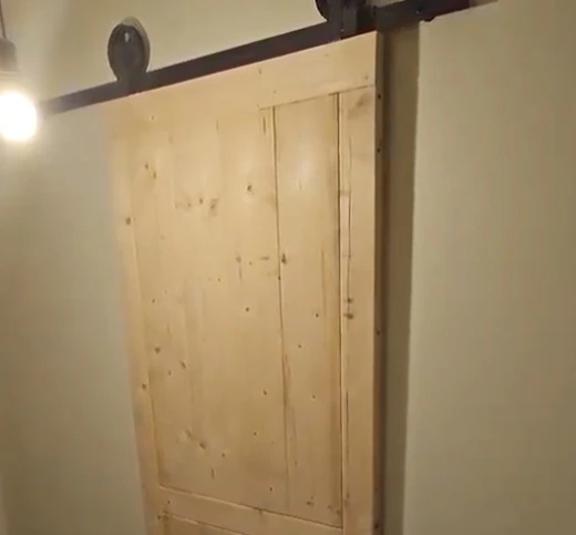 Maatwerk barn door als schuifdeur voor een badkamer met zwart schuifsysteem
