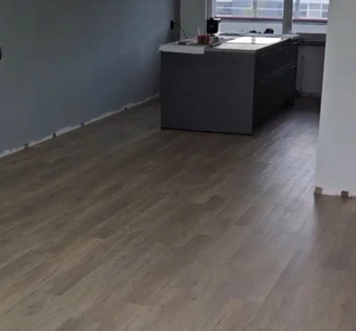 Klik-PVC vloer gelegd in woonkamer en rond een kookeiland