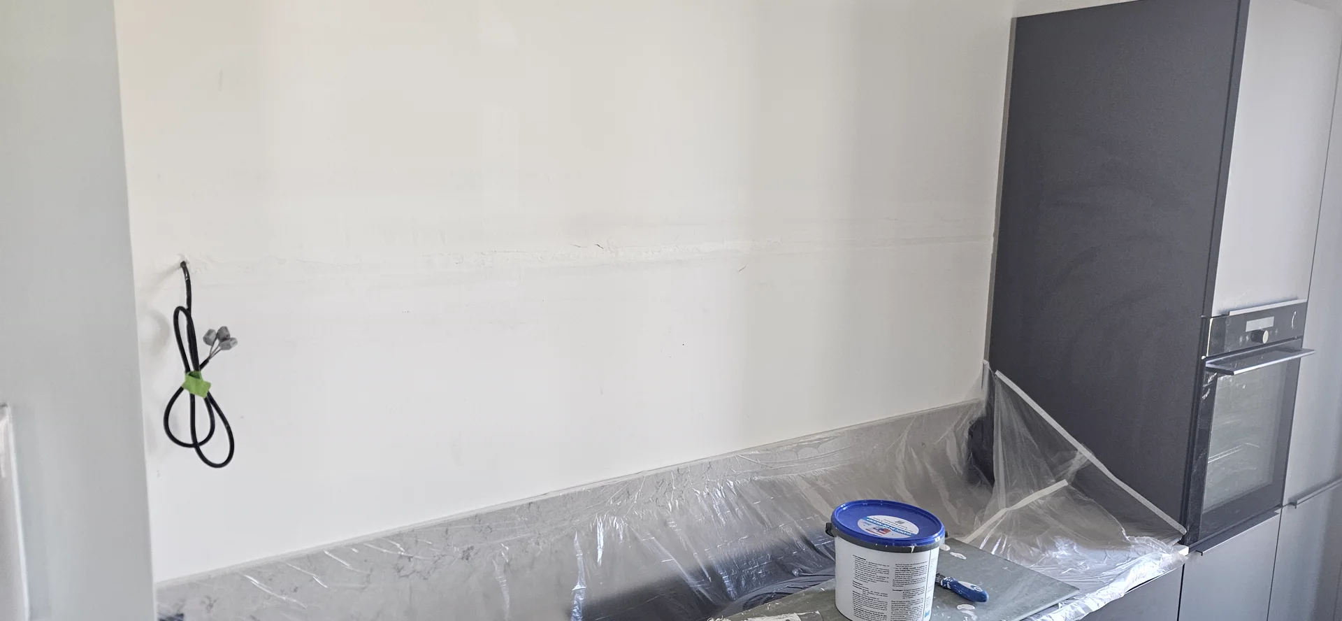 Herstelde keukenwand tijdens de afwerking