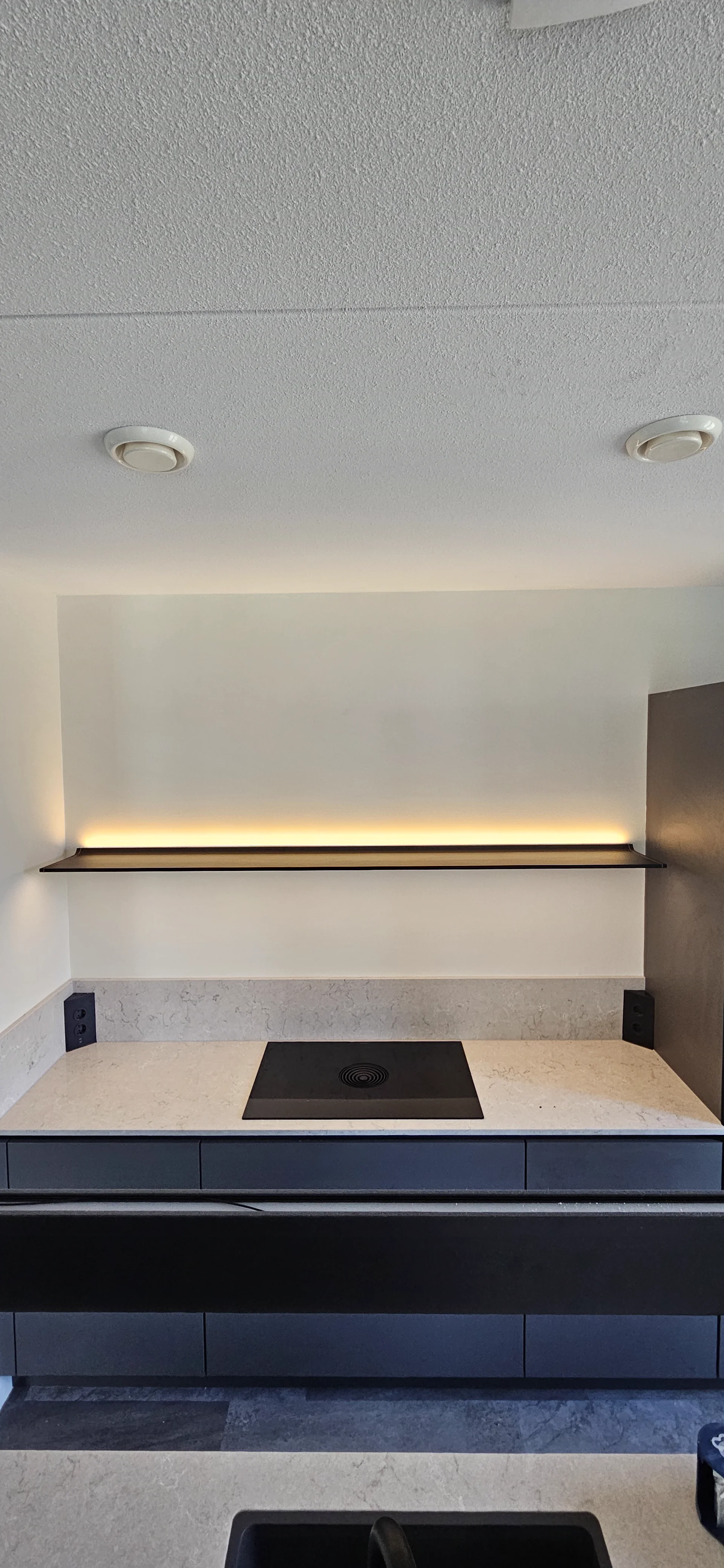 Zware stalen keukenplank met ledverlichting opnieuw veilig bevestigd boven de kookplaat