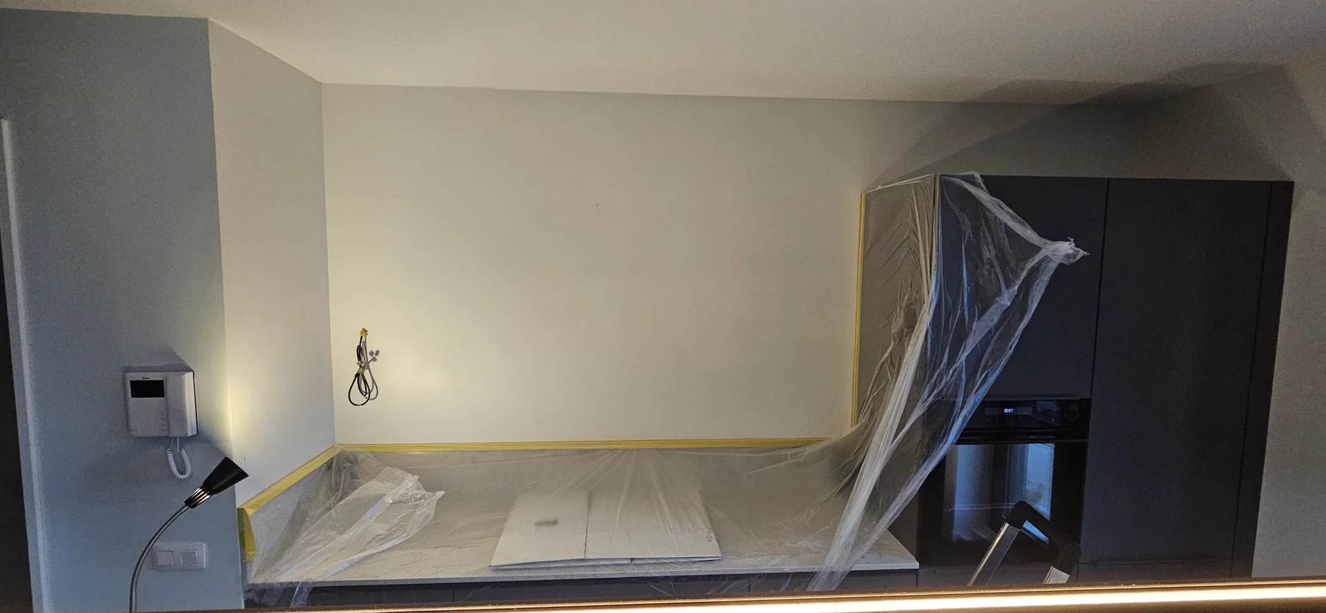 Afgeplakte keukenwand tijdens het schilderen